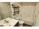 Bathroom featuring a tub/shower, a wood and metal shelving unit, toilet, and a modern sink at 2378 Charleston Se Pt, Atlanta, GA 30316