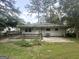 View of a backyard featuring a wooden deck, a concrete pad, and mature trees providing ample shade at 2327 Scotty Cir, Decatur, GA 30032