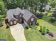 Aerial view of a beautiful brick home with lush landscaping and a long drive at 220 Lavender Oasis, Peachtree City, GA 30269