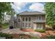 The back exterior features multiple windows, a stone patio and landscaping with a lush green lawn at 220 Lavender Oasis, Peachtree City, GA 30269