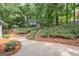 Scenic backyard with a paved patio, lush landscaping, and a charming elevated playhouse at 220 Lavender Oasis, Peachtree City, GA 30269