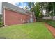 Well-maintained backyard featuring a lush lawn, mature trees, and a brick exterior on the home at 220 Lavender Oasis, Peachtree City, GA 30269