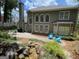 Expansive backyard features a paver patio, lush landscaping, rock waterfall, and blue Adirondack chairs for relaxation at 220 Lavender Oasis, Peachtree City, GA 30269