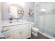 Modern bathroom with a sleek vanity, a round mirror, and a walk-in shower with glass doors at 220 Lavender Oasis, Peachtree City, GA 30269