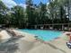 Spacious community pool with lounge chairs and umbrellas, surrounded by lush trees at 220 Lavender Oasis, Peachtree City, GA 30269