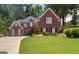 Charming two-story brick home with manicured lawn and mature trees providing shade at 220 Lavender Oasis, Peachtree City, GA 30269