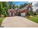 Charming two-story brick home with well-manicured landscaping, a spacious driveway, and a two-car garage at 220 Lavender Oasis, Peachtree City, GA 30269