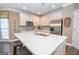 Modern kitchen with stainless steel appliances, a large marble island, and a convenient breakfast bar at 220 Lavender Oasis, Peachtree City, GA 30269