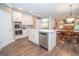Modern kitchen with stainless appliances, center island, and open layout to a dining area with a fireplace at 220 Lavender Oasis, Peachtree City, GA 30269