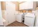 Functional laundry room with white cabinetry, washer, and dryer at 220 Lavender Oasis, Peachtree City, GA 30269