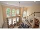 A view of the living room with large windows, a ceiling fan, and an open staircase at 220 Lavender Oasis, Peachtree City, GA 30269