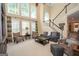 Bright living room with large windows, hardwood floors, and a staircase to the upper level at 220 Lavender Oasis, Peachtree City, GA 30269
