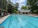 Community pool with lounge chairs, tables, and umbrellas creating a relaxing atmosphere at 220 Lavender Oasis, Peachtree City, GA 30269