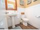 Cozy powder room with a pedestal sink, toilet, and wainscoting for a touch of elegance at 220 Lavender Oasis, Peachtree City, GA 30269
