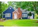 Charming blue cottage-style home with brick chimney and well-manicured lawn featuring a swing set at 6391 Katherine St, Douglasville, GA 30134