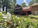 Inviting backyard with a screened porch and a deck, surrounded by lush landscaping and colorful flowers at 280 Emerald Lake Dr, Fayetteville, GA 30215