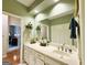 Bathroom features a large mirror, white cabinets, and green walls, creating a serene atmosphere at 280 Emerald Lake Dr, Fayetteville, GA 30215