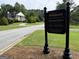 The Woodlands community sign with a view of a house with classic architecture and manicured lawns at 280 Emerald Lake Dr, Fayetteville, GA 30215