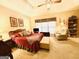 Spacious bedroom featuring a tray ceiling, ceiling fan, and a comfortable seating area at 280 Emerald Lake Dr, Fayetteville, GA 30215