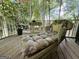 Relaxing covered porch features wicker chaise lounge and serene wooded view at 280 Emerald Lake Dr, Fayetteville, GA 30215