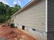 Side view of a home showing beige siding, concrete block foundation and access stairs at 436 Laurel Trce, Carrollton, GA 30116