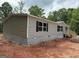 Exterior side view of a newly built home, showing the siding and block foundation in a wooded area at 436 Laurel Trce, Carrollton, GA 30116