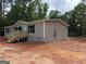 Exterior side view of a newly built home, showing the siding and block foundation in a wooded area at 436 Laurel Trce, Carrollton, GA 30116