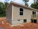 Exterior side of the house with light brown siding, concrete foundation, and a window at 436 Laurel Trce, Carrollton, GA 30116