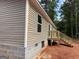 Side of the house with light brown siding, concrete foundation, and wooden stairs at 436 Laurel Trce, Carrollton, GA 30116