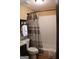 Bathroom featuring shower with gray and brown patterned shower curtain, complemented by white tile at 5880 Mulberry St, Austell, GA 30168