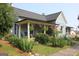 Charming home featuring a welcoming covered porch decorated with patriotic bunting and lush landscaping at 5880 Mulberry St, Austell, GA 30168