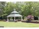 Lawn with gazebo, flowers, and retaining wall surrounded by large trees in Austell, Georgia at 5880 Mulberry St, Austell, GA 30168