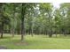 Tree covered lawn with walking path, and disc golf basket in Austell, Georgia at 5880 Mulberry St, Austell, GA 30168