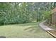Expansive green backyard with mature trees and a stone path, offering a peaceful and private outdoor retreat at 110 Heatherwood Dr, Fayetteville, GA 30215