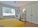 Bright bedroom featuring a big window, white chair, and hardwood floors at 110 Heatherwood Dr, Fayetteville, GA 30215