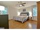 Cozy bedroom with hardwood floors, ceiling fan, and large windows at 110 Heatherwood Dr, Fayetteville, GA 30215