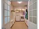 Well-lit laundry room with washer, dryer, storage cabinets, and tiled floor at 110 Heatherwood Dr, Fayetteville, GA 30215