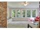 Bright sunroom with large windows, a brick accent wall, and neutral carpeting at 110 Heatherwood Dr, Fayetteville, GA 30215