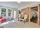 Cozy sunroom with brick and multiple windows, furnished with chairs and a small table at 110 Heatherwood Dr, Fayetteville, GA 30215