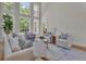 Sunlit living room with hardwood floors, tall windows, comfortable seating and a view of the greenery at 140 Olivia Ct, Fayetteville, GA 30215