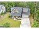 Aerial elevation of the two story home with a grey roof, a covered front porch, and a long driveway at 9148 Tarnwood Dr, Villa Rica, GA 30180