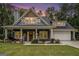 Charming home at dusk featuring a welcoming front porch with rocking chairs and well-manicured landscaping at 9148 Tarnwood Dr, Villa Rica, GA 30180
