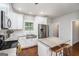 Bright eat-in kitchen boasts white cabinets, stainless appliances, granite countertops and counter stool seating at 9148 Tarnwood Dr, Villa Rica, GA 30180