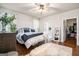 Spacious main bedroom featuring a ceiling fan, hardwood floors, and ensuite bathroom and walk-in closet at 9148 Tarnwood Dr, Villa Rica, GA 30180