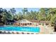 Resort-style pool surrounded by lounge chairs and lush greenery, perfect for relaxation at 9148 Tarnwood Dr, Villa Rica, GA 30180