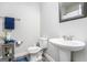 Powder room featuring pedestal sink, wood look floors, and blue towel accents at 9148 Tarnwood Dr, Villa Rica, GA 30180