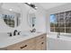 Elegant bathroom with double vanities, a soaking tub, and a window offering a serene view at 3797 Churchill Sw Dr, Marietta, GA 30064