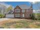 Traditional two-story brick home with attached garage and dormer window, fronted by a lawn with trees at 3797 Churchill Sw Dr, Marietta, GA 30064