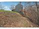 Exterior view of the backyard of a two-story home with stairs leading up to the house and foliage at 6448 Mobilis Ct, Sugar Hill, GA 30518