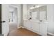 This bathroom features a double vanity, tile flooring, and a doorway leading to the bedroom at 6448 Mobilis Ct, Sugar Hill, GA 30518